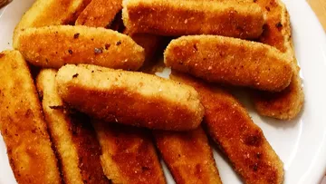 Fried sticks lie on a white plate.
