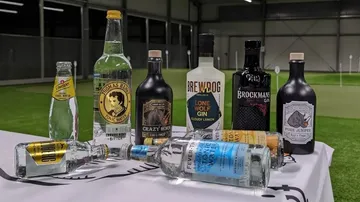 The bottle and glasses are placed on an indoor table.