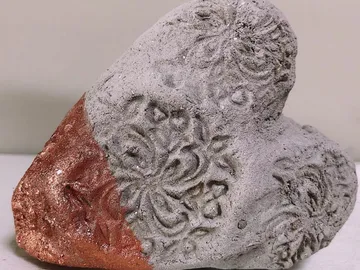 Gesteinsstück mit dekorativen Mustern und rötlicher Fläche.