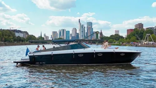 Boat with people on river, city skyline.