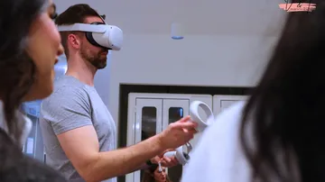 Mann trägt VR-Headset und steuert möglicherweise ein Spiel.