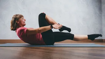 Woman doing an abdominal exercise on a yoga mat.