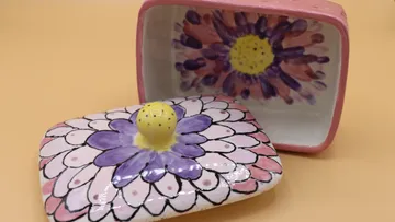 Colourful ceramic jar opened, shows blooming interior pattern