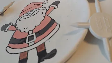 Plastic plate with Santa motif, drawing on a table.