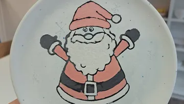 Ein Teller zeigt einen fröhlichen Weihnachtsmann mit Armen.