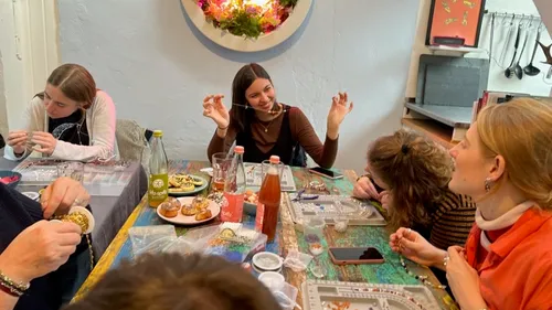 Frauen basteln gemeinsam Schmuck an einem Tisch.