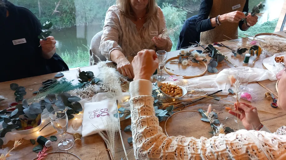 Women create creative decorations around a table.