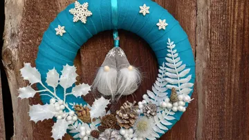 Door wreath with festive decoration on a wooden wall.