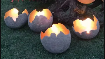 Spherical light sources emit warm light onto grass.