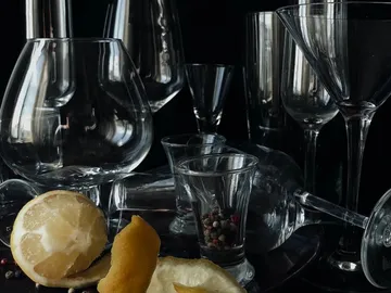 Gläser stehen gemischt mit Zitronen und Pfefferkörnern.