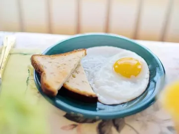 Ein Teller mit Spiegelei und geröstetem Brot.