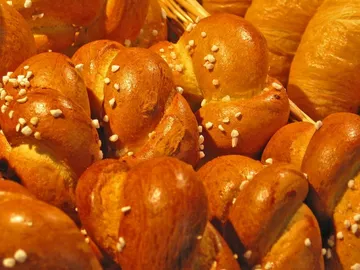 Goldbraune Brötchen liegen angeordnet in einem Korb.