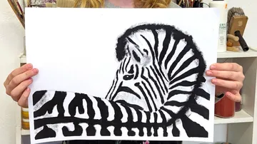 Ein Kind hält eine Zeichnung eines Zebras in Schwarzweiß.