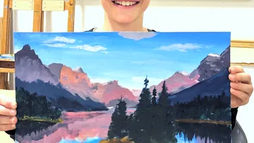 Junge hält ein Gemälde einer Landschaft mit Bergen und Wasser.