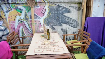 Cafétisch im Freien mit Stühlen, Graffiti-Wandhintergrund.