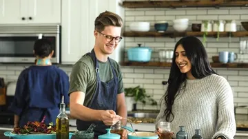 Young man cooks together with woman in a modern kitchen.