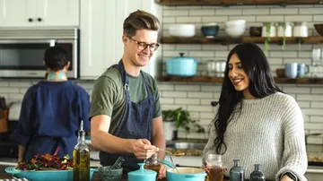 Two people cook together in a modern kitchen.