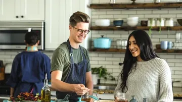 Two people cook together in a modern kitchen.