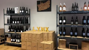 Weinflaschen und Kisten in den Regalen im Geschäft.