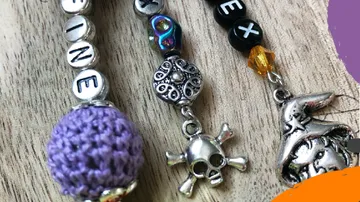 Bunte Schlüsselanhänger mit Perlen und Charms auf Holz.