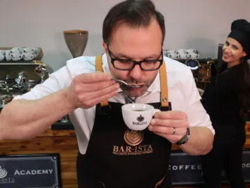 Ein Mann trinkt Kaffee in einer Barista-Schule.