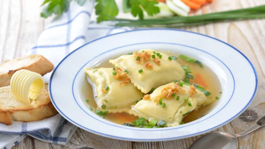 Plate with dumplings filled in broth, with bread.
