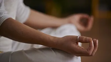 Hands in meditation position, relaxed in quiet surroundings.