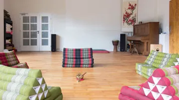 Colourful futons stand in an empty room with wooden floors.