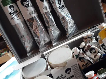 Künstlerische Malutensilien in einer Kiste, sorgfältig angeordnet.