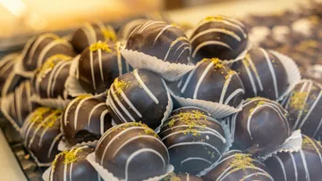 Chocolate balls lie stacked on a bright surface.