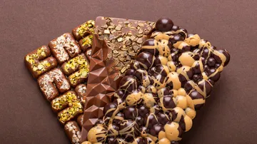 Three chocolate bars lie on a brown background.