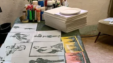 Leinwände liegen auf dem Tisch, Farben und Pinsel stehen bereit.