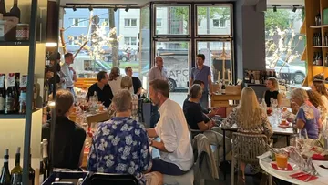 People listen to two speakers in a modern restaurant.