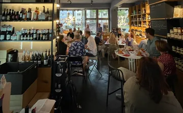 Leute, die in einer gemütlichen Weinhandlung essen.