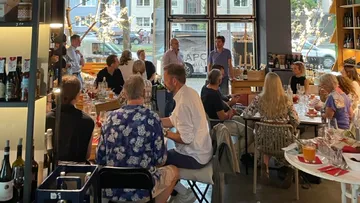 Menschen sitzen in einem Restaurant, hören zu und essen.