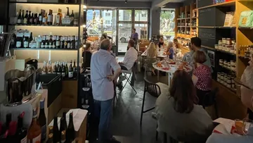 Wine shop with guests enjoying the presentation, relaxed atmosphere.