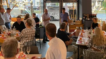 People are having a conversation at a restaurant over dinner.