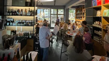 Eine Gruppe von Menschen sitzt in einem Weinladen.