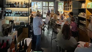 Wine bar with guests who listen carefully to a presentation.