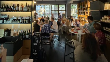 Weinregal mit Gästen, die in einem Restaurant speisen.