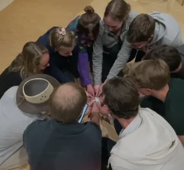 Many people sit around a table and work together.