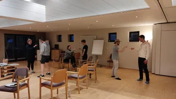 Group discussion in a bright room with chairs.