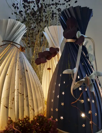 Paper lamps glow softly against a background of dried flowers.