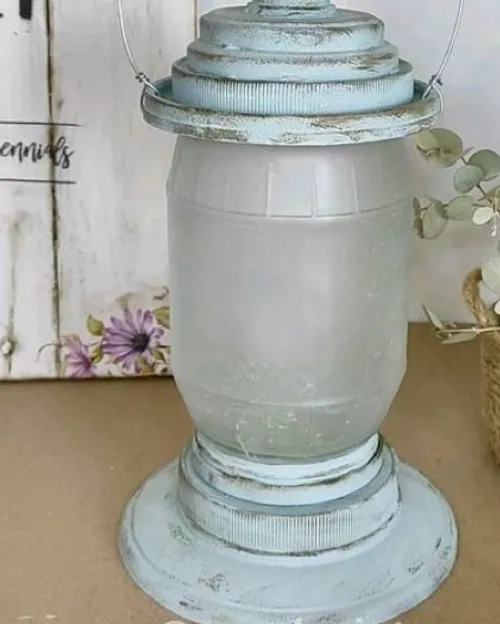 Rustikale Metalllaterne mit Pflanzen in der Nähe.