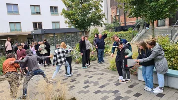 Gruppenspiel im Freien; Menschen interagieren in einem Garten.