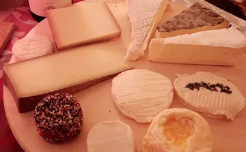 A cheese platter with various types of cheese on wood.