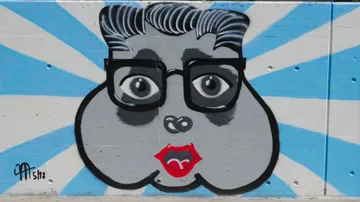 Graffiti-Kunstwerk zeigt ein Gesicht mit großen Augen.