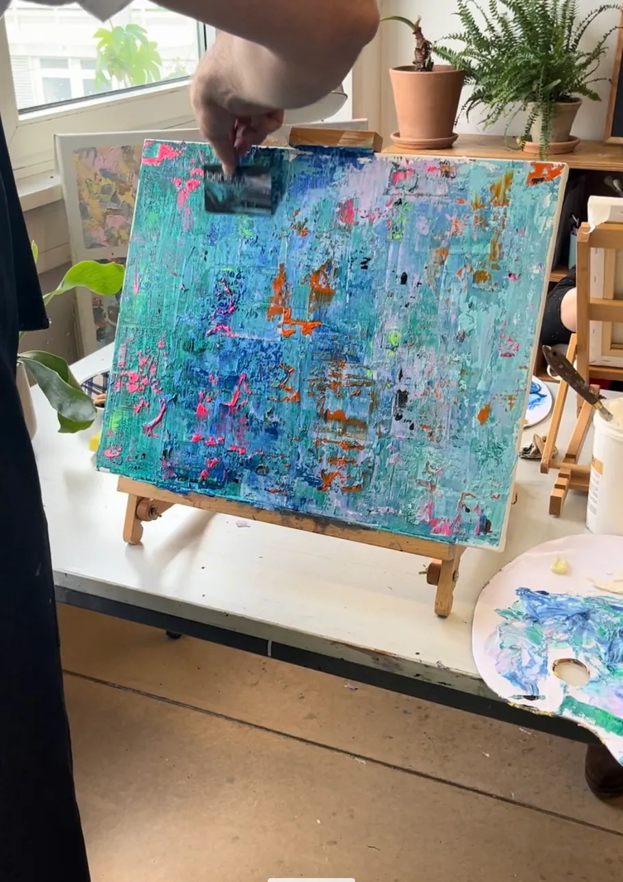 Person, die abstrakte Kunstwerke mit einem Spachtel malt.