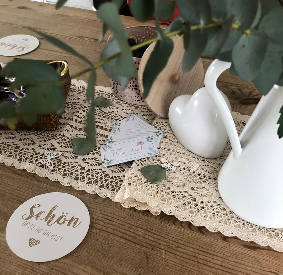 Decorative table with lace, vase, and card.