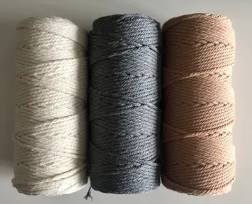 Three spools of thread in different colors stand next to each other.